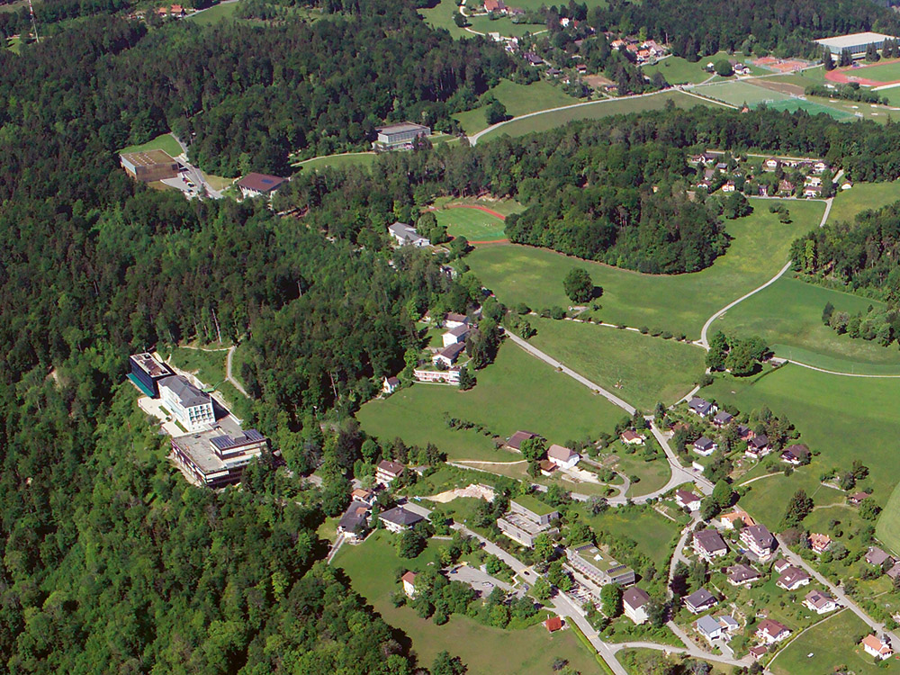 Die Luftaufnahme von 2007 zeigt das einstige Kurhaus mit der benachbarten Seilbahnstation und den späteren Erweiterungen. Im Bild direkt darüber ist die Lichtung, auf der die Energiezentrale gebaut werden soll. (Foto: ETH-Bi­bliothek Zürich, Bildarchiv / R. Ziebold)