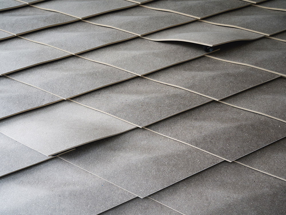 Individuell geformte Wandpaneele, gefertigt aus Kaffeesatz und gebrauchten Pappbechern, schmücken zwei Wände in der STEP2-Unit. (Foto: ROK Architekten)