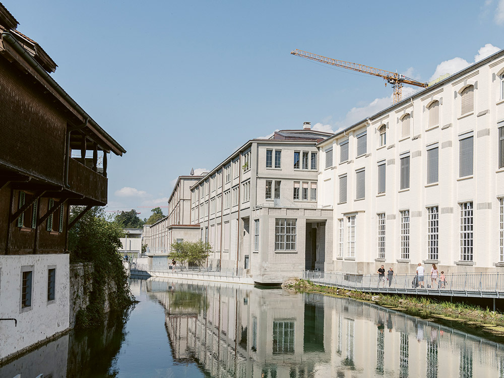 Der umgenutzte Hallenkomplex PM 1-4 am rechten Flussufer wird von einem öffentlichen Fussweg begleitet.